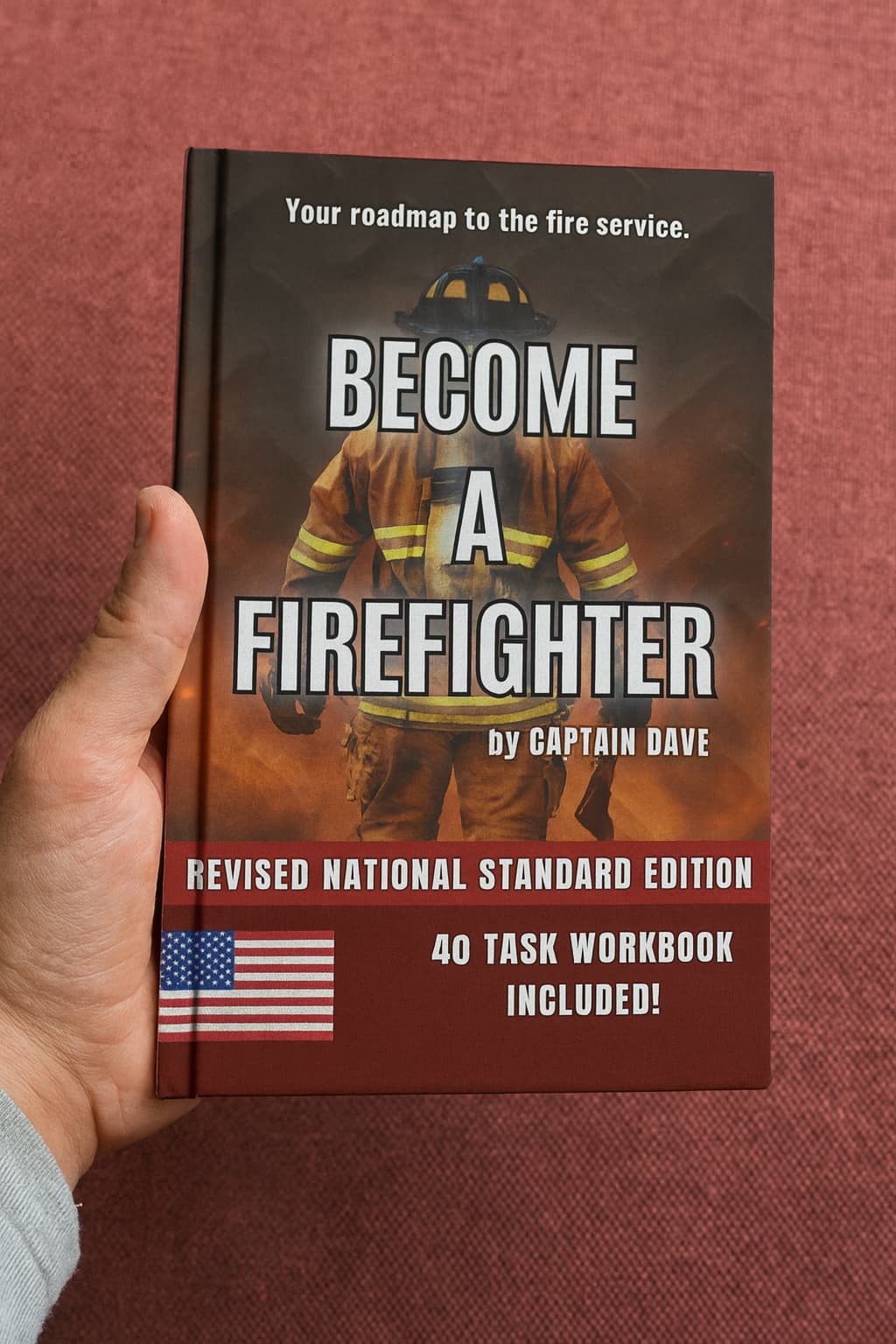 Hand holding the book “Become a Firefighter – Updated National Edition” by Captain Dave, a firefighter career guide for testing, interviews, and hiring success.